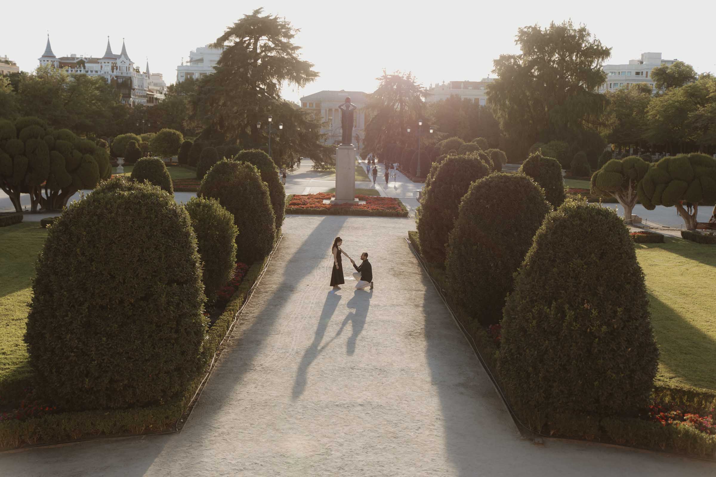 fotografia emotiva y natural del momento de una propuesta de matrimonio sorpresa en el parque del retiro de madrid a la hora del atardecer